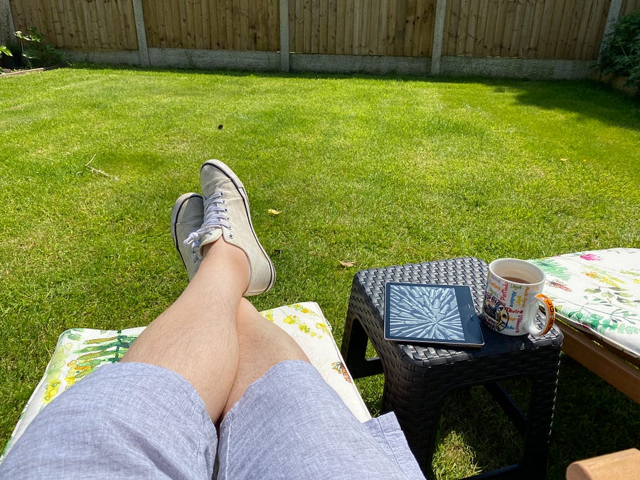 The author putting his feet up in his parent’s sunny garden