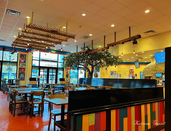 Image capturing the cozy ambiance of Malawi’s Pizza in Provo with tables, chairs and decors. Photo by restaurant reviewer, Katerina Gasset of the Gasset Group Mother-and-Son Real Estate Team…