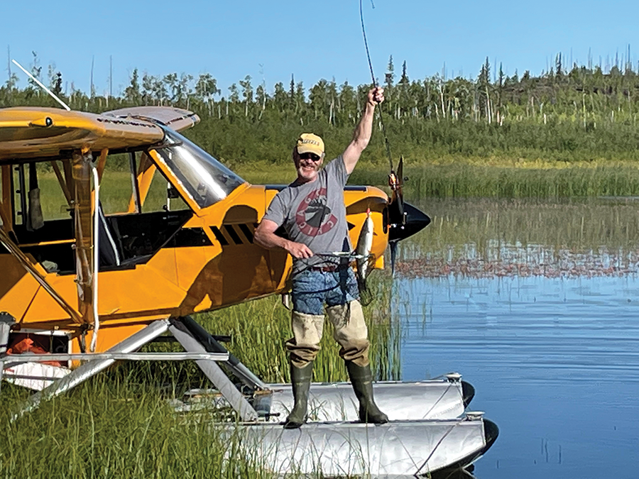 Photo of pilot fishing off a pontoon plane.