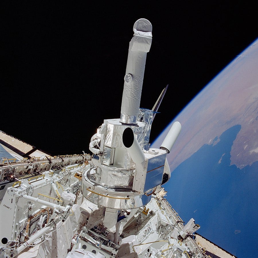 Photograph of Spacelab-2 and assorted instruments sticking out of the open payload bay of Challenger during STS-51-F. To the right is Earth; the Mediterranean is visible below (from the viewer’s perspective) North Africa.