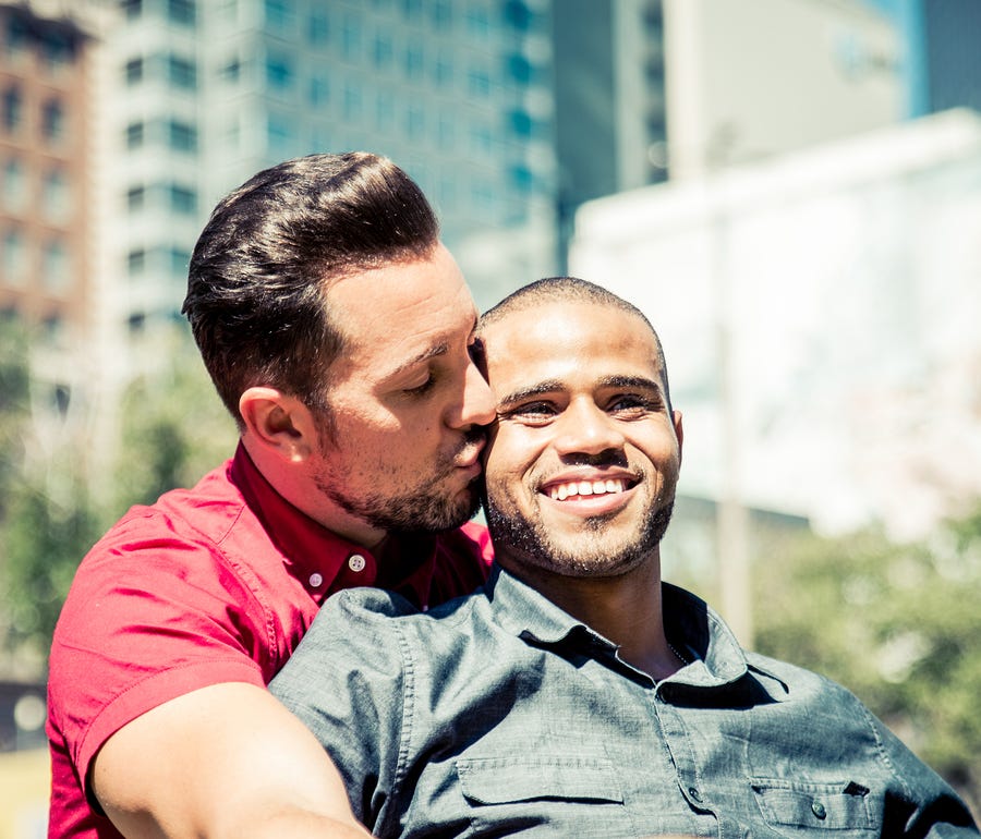 One man holding another in a loving embrace.