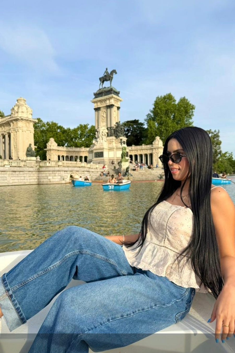 enjoying a boat ride in El Retiro Park, Madrid, with the monument to King Alfonso XII visible in the background