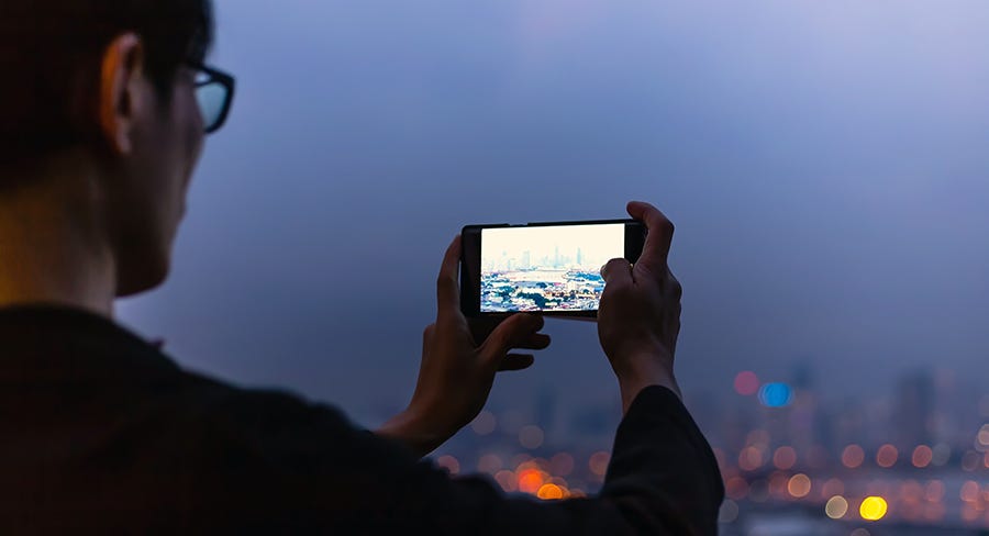 A tourist takes a vacation photo of a skyline.