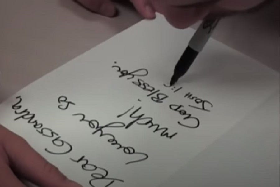 A person writing autograph with mouth