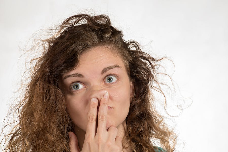 Lady with fingers up her nose looking like she has no common sense