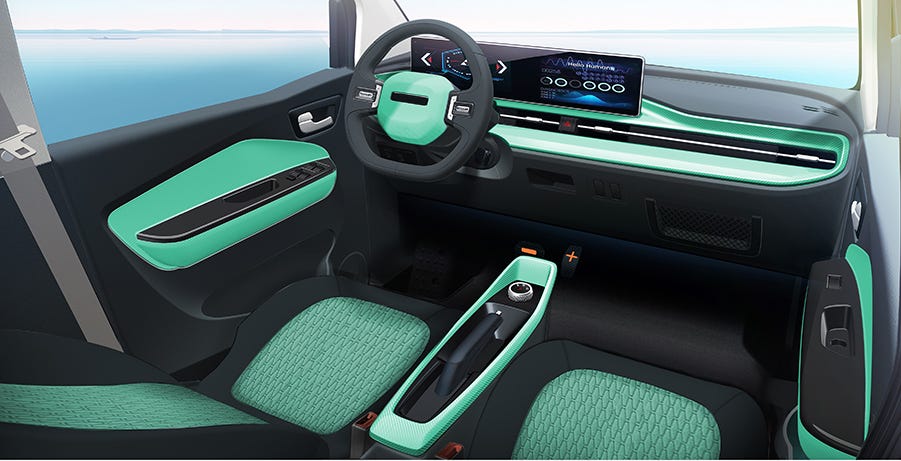 Interior del coche. Asientos tapizados en tela. Volante ergonómico. Pantalla multimedia, aire acondicionado. Color verde.