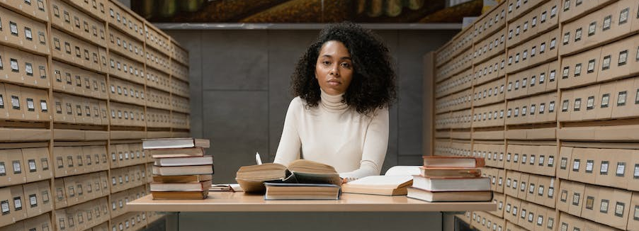 woman at a desk with books surrounding her