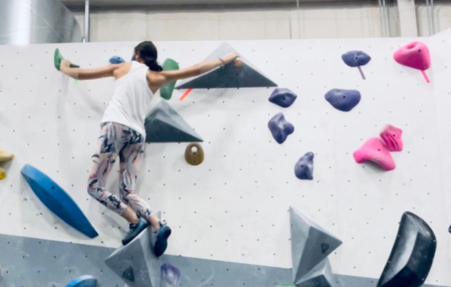 Person on grey and white climbing wall, climbing on geometric shapes Liora W on Medium