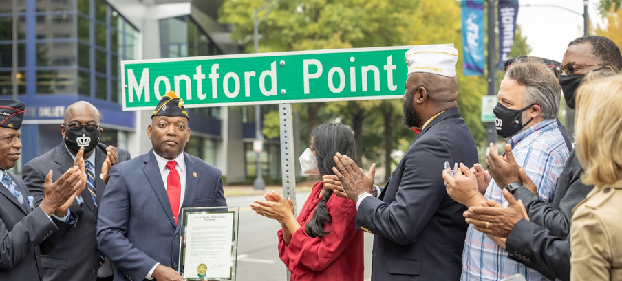 People clapping, celebrating street renaming.