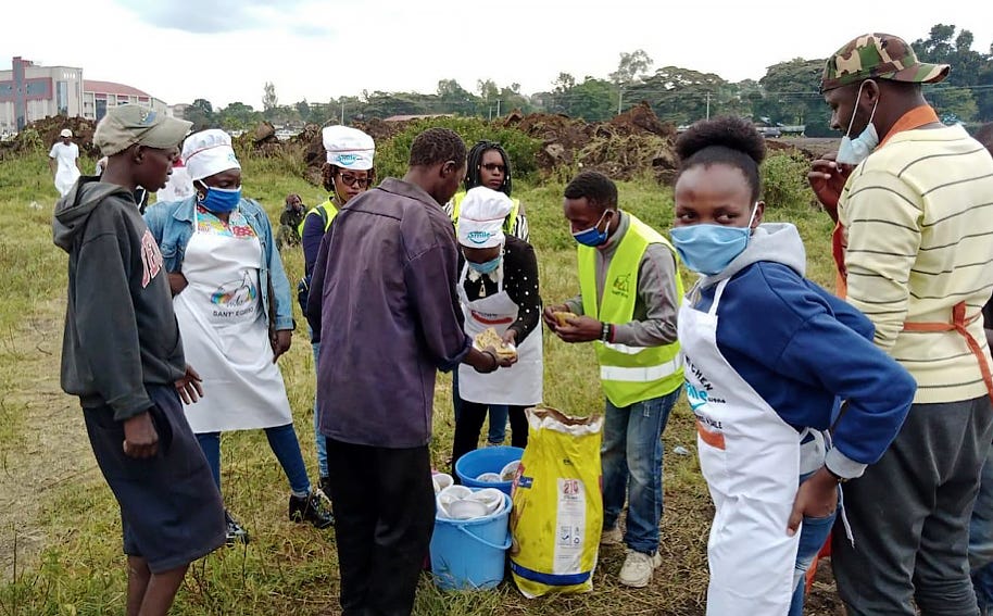 A team of people distributes food in a field.