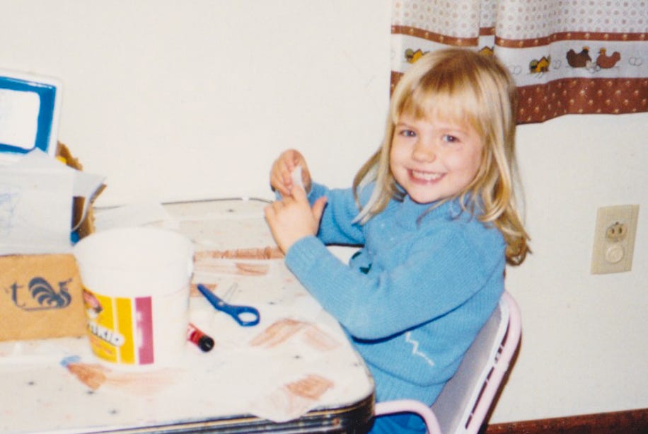 A photo of me as a 5-year-old sitting at a messy craft table
