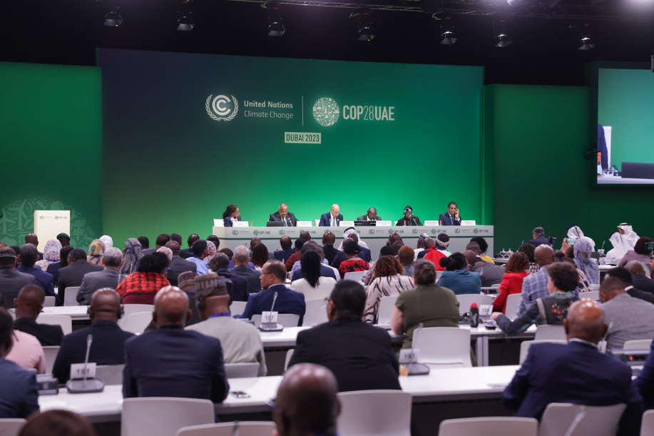 Panel of leaders at COP28 seated at a long table in front of an audience