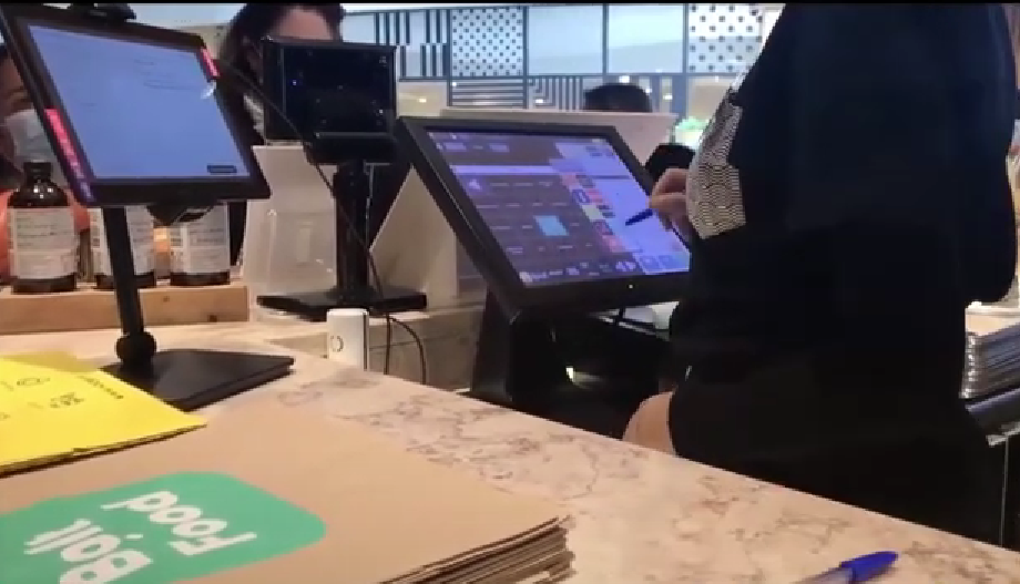 A person entering an order into the register at a restaurant.