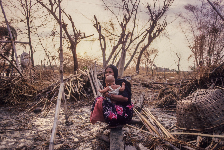 A mother with her child sits amid the remains of her home in the 1991 cyclone affected area of Anwara upazila, in Chittagong. The 1991 cyclone had initiated a 6-meter storm surge over a wide area, killing at least 138, 000 people and leaving as many as 10 million homeless. Photo: Shahidul Alam