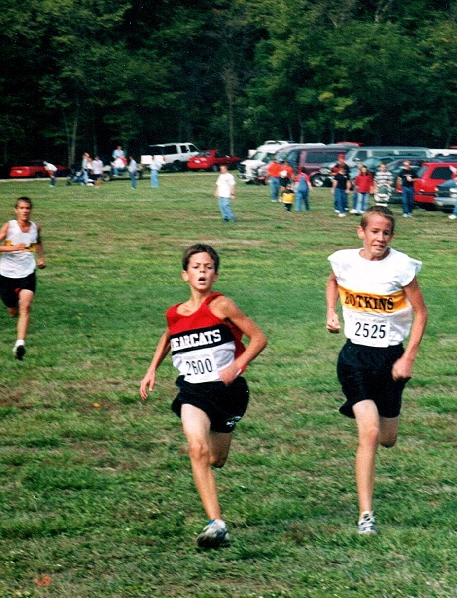 Luke Brenneman pictured running beside another competitor who is within his age range but clearly larger in stature.