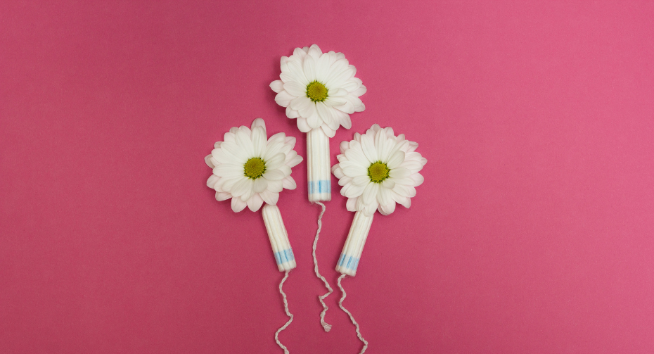 A vibrant pink background showcases tampons adorned with delicate daisies, creating a visually appealing and feminine image. The floral embellishments add a touch of elegance to the essential feminine hygiene product, merging practicality with aesthetics in a seamless blend of functionality and beauty.