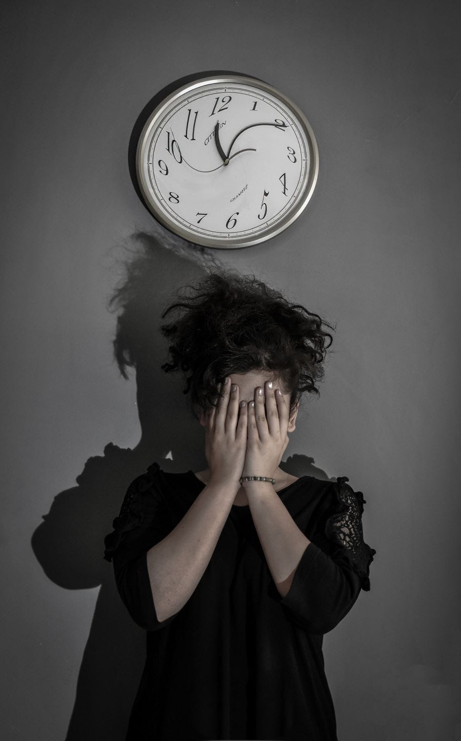 A person standing beneath a clock with their hands covering their face in anguish. The clock’s numbers and hands are distorted