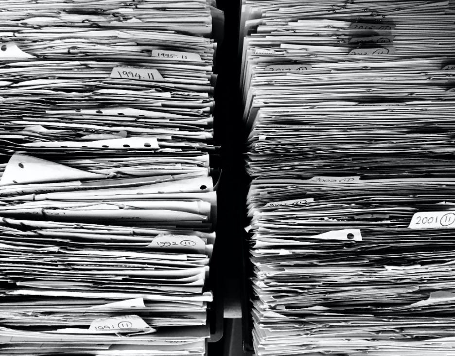 Top down view of two adjacent and open filing cabinets showing two rows of slightly messy files and papers