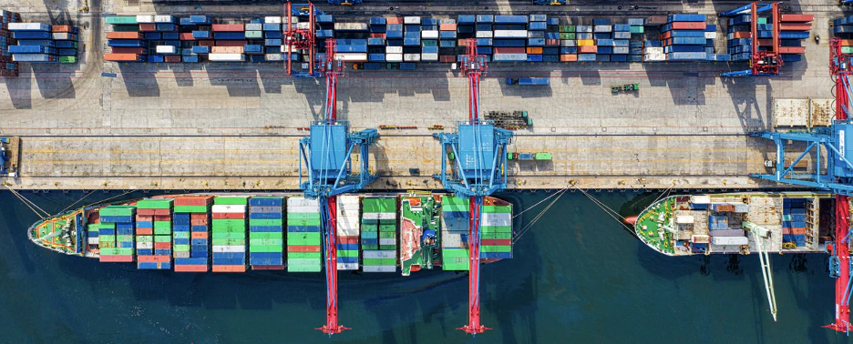 Aerial picture of a port with 2 container ships and numerous shipping containers