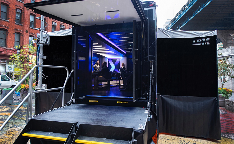 View of people working through the open doors of a black IBM truck in New York