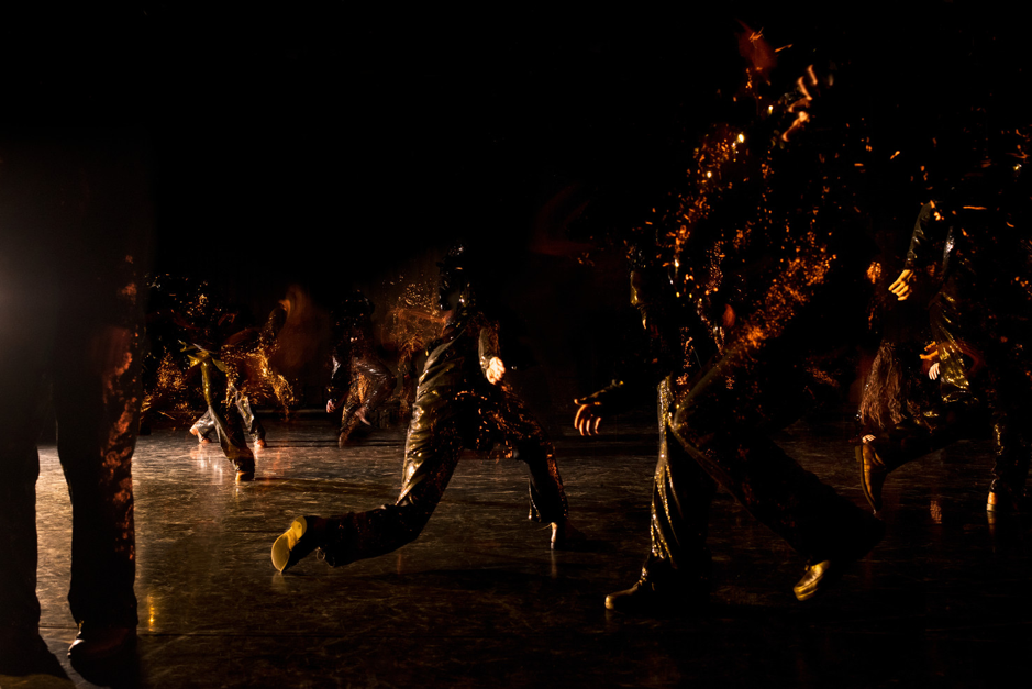 Image of Mia Habib’s dance performance Gallarhorn shows dancers in the dark with shiny costumes.