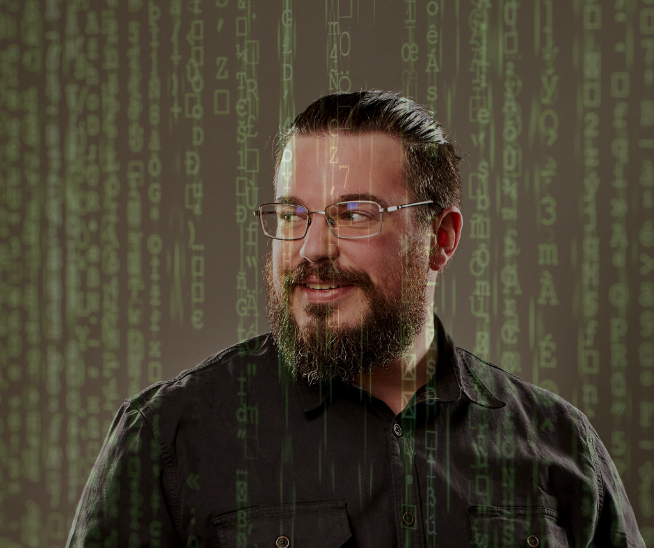 A portrait of a man (Justin) glancing over his shoulder. The Matrix-style green code is falling all around him.