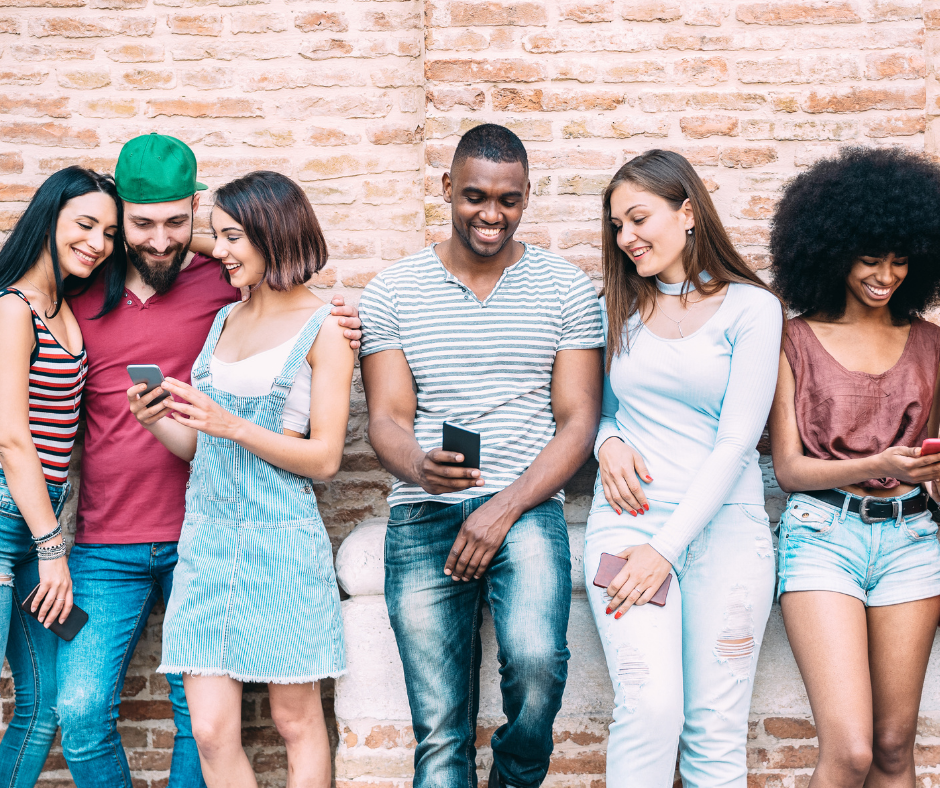 An image of a diverse group of young people looking at their mobile phones