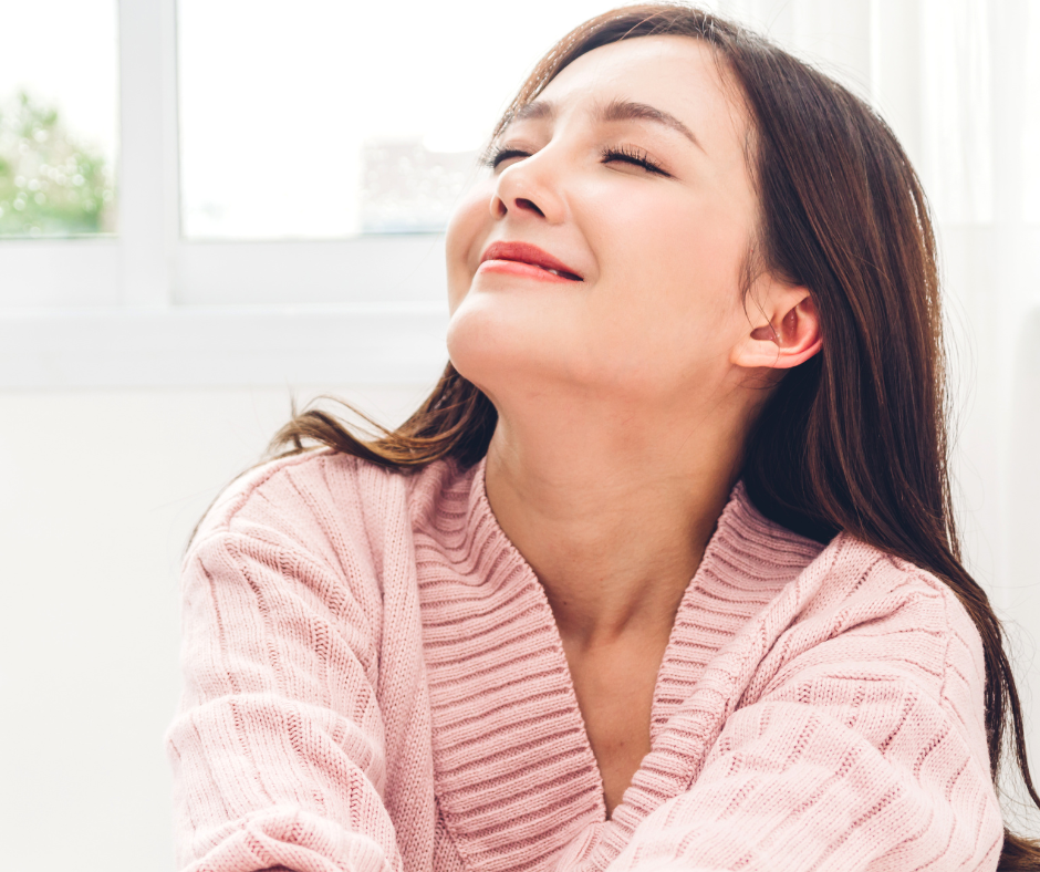 How to feel calm when emotionally triggered. Photo of woman whose head iss sslightly turned up feeling good inside.