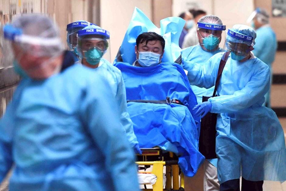 Medical staff rushing a sick man in a trolley down a hallway