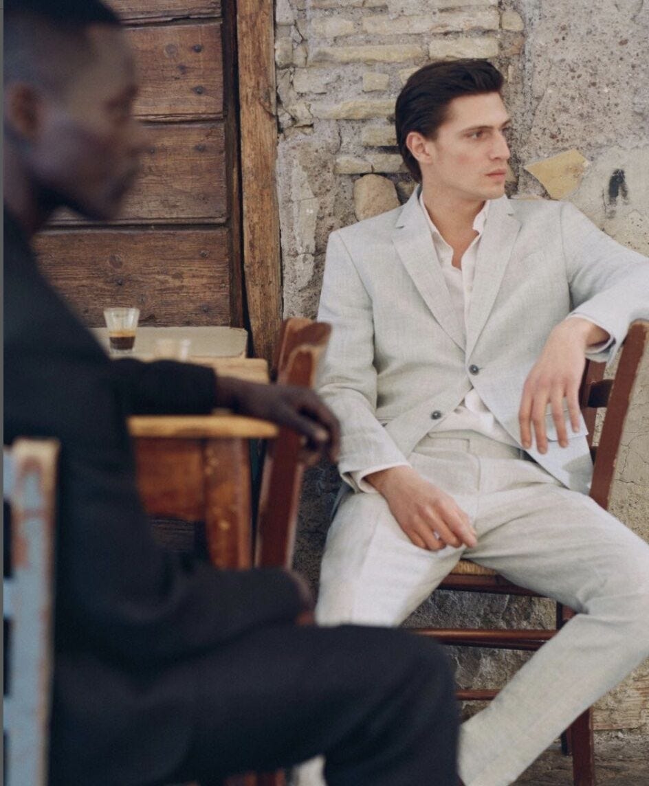 Man wearing a suit slouching in a chair