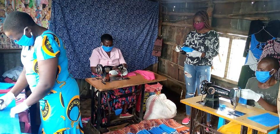 Four women focus on sewing masks.