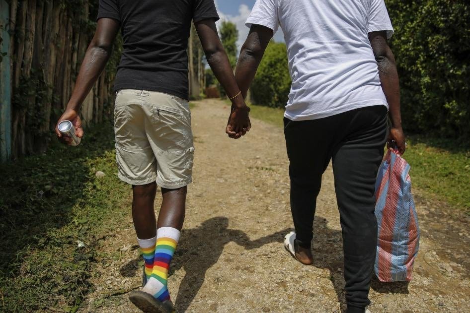 Two people walking hand-in-hand. One is wearing rainbow socks.