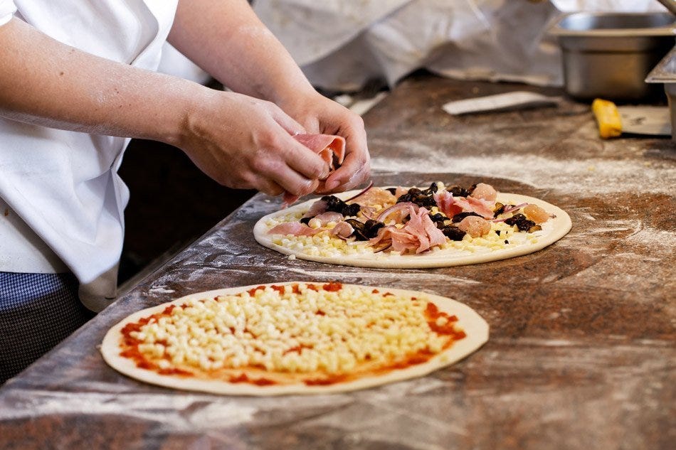 Chef making two pizzas, because this article compares JavaScript promises to ordering a pizza