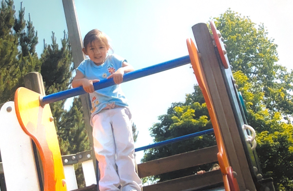 A young Aria plays at a park on a sunny day.