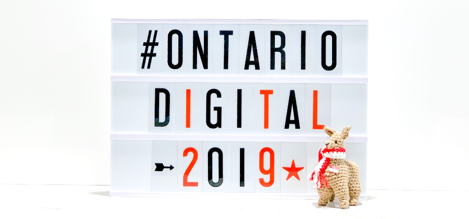 Block letters on a white screen which read #Ontario Digital 2019 with a holiday-themed llama on the bottom right.