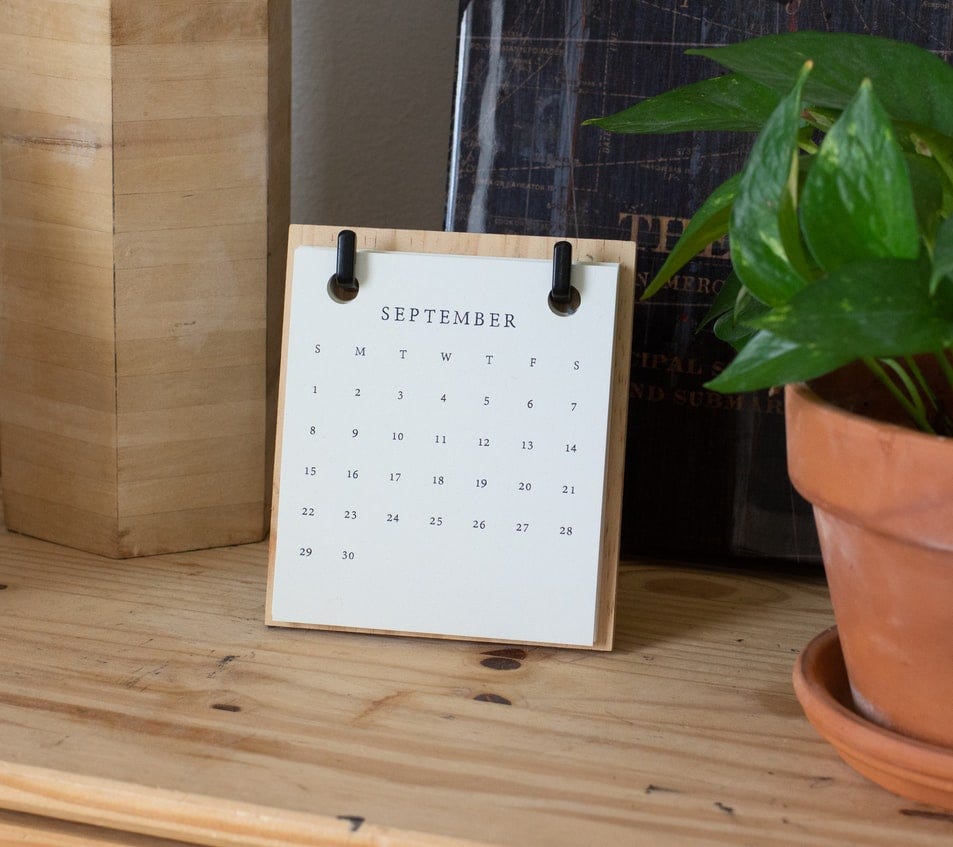 Dresser top with mini calendar of September and a potted plant