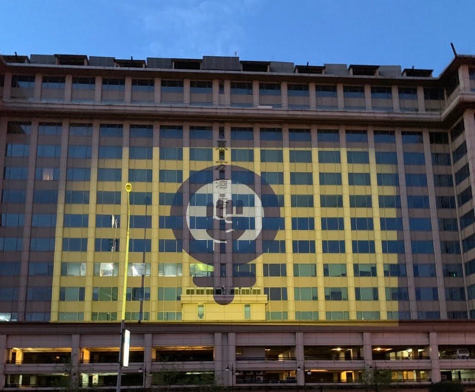 The Feminist Coalition logo projected onto a building