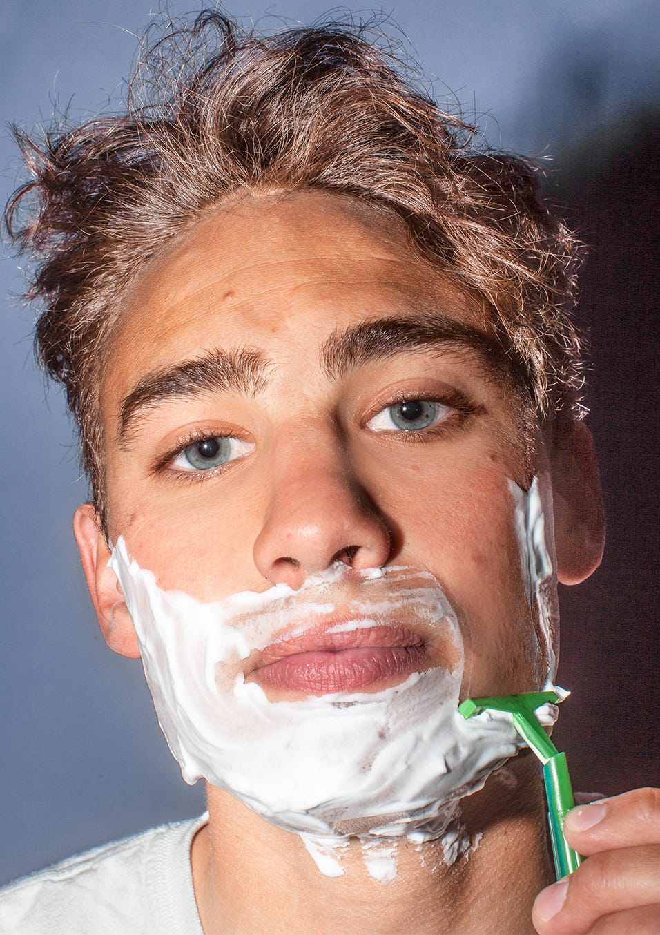 Man using a razor and shaving cream on his face