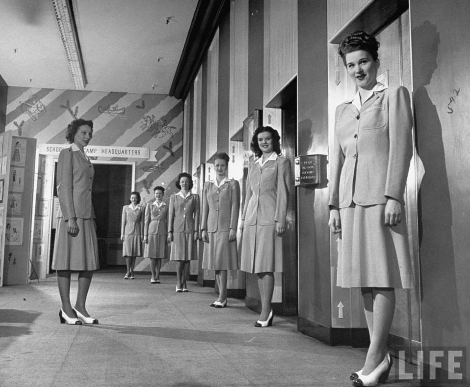 A photo from Life Magazine depicts several female elevator operators outside of an elevator bank.