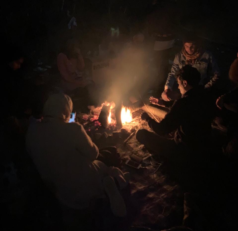 Refugiados sirios se reúnen en torno a un fuego en el pueblo de Kuplu. (Foto: Ali Kut / TRT World)