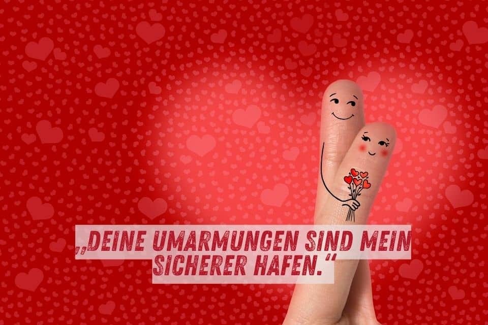 Das Bild zeigt zwei Finger mit aufgemalten Gesichtern und Umarmungen, wobei einer Blumen hält. Der Hintergrund ist rot mit vielen kleinen Herzen. Unten im Bild steht der Text: