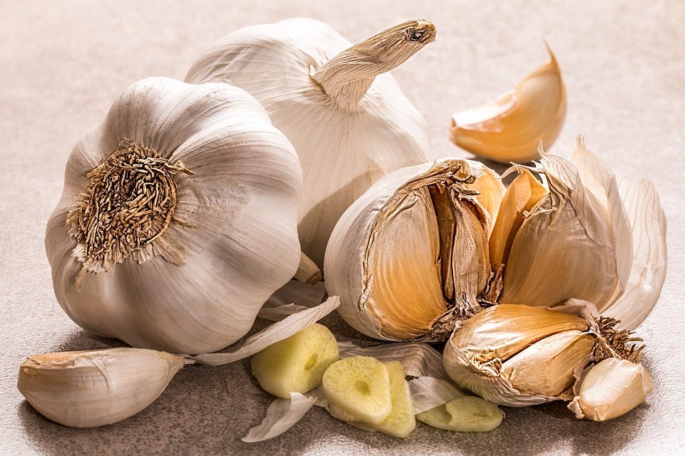 A close-up of garlic cloves and whole garlic.