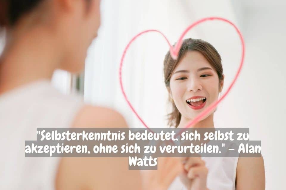 Eine junge Frau steht vor einem Spiegel und zeichnet mit Lippenstift ein Herz darauf. Sie lächelt glücklich. Unten im Bild befindet sich ein Zitat von Alan Watts auf Deutsch: