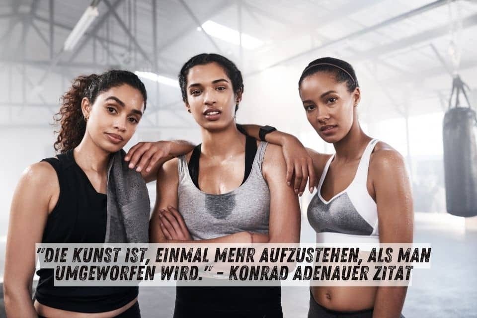 Das Bild zeigt drei sportliche Frauen in Trainingskleidung in einem Fitnessstudio. Sie sehen erschöpft, aber entschlossen aus. Der Hintergrund ist verschwommen, und im Vordergrund steht das Zitat von Konrad Adenauer: