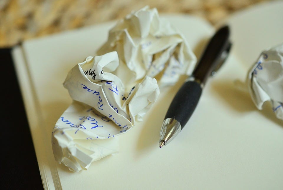 A pen and a crumpled piece of a paper.