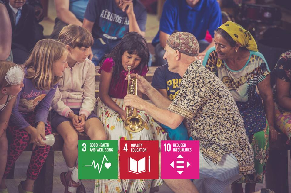Campaigner teaching children to play the trumpet plus logo’s of related SDGs