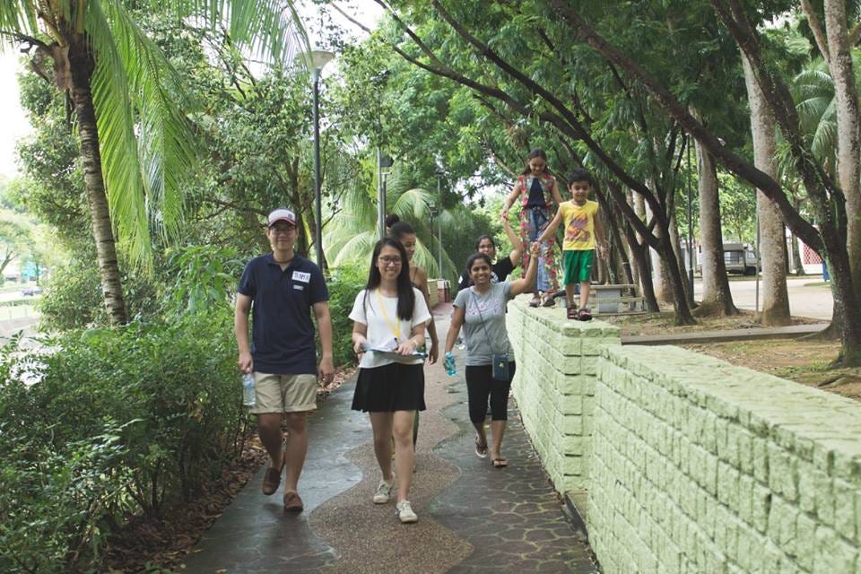 Me walking along a garden path with participants, including a mother with children