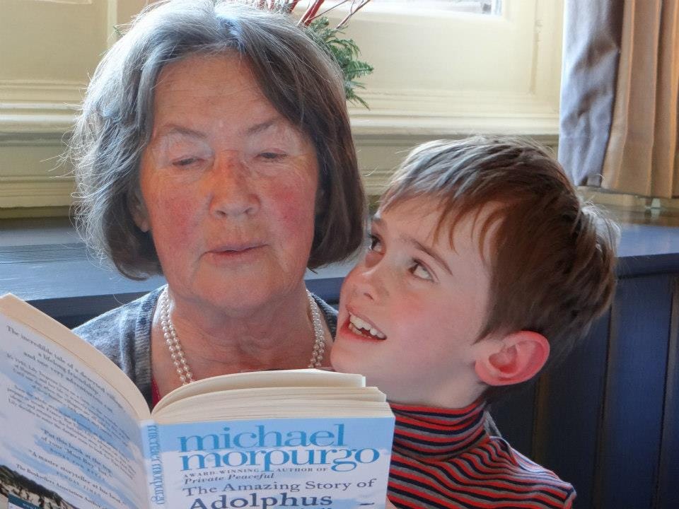 A grandmother is reading a story to her grandson.