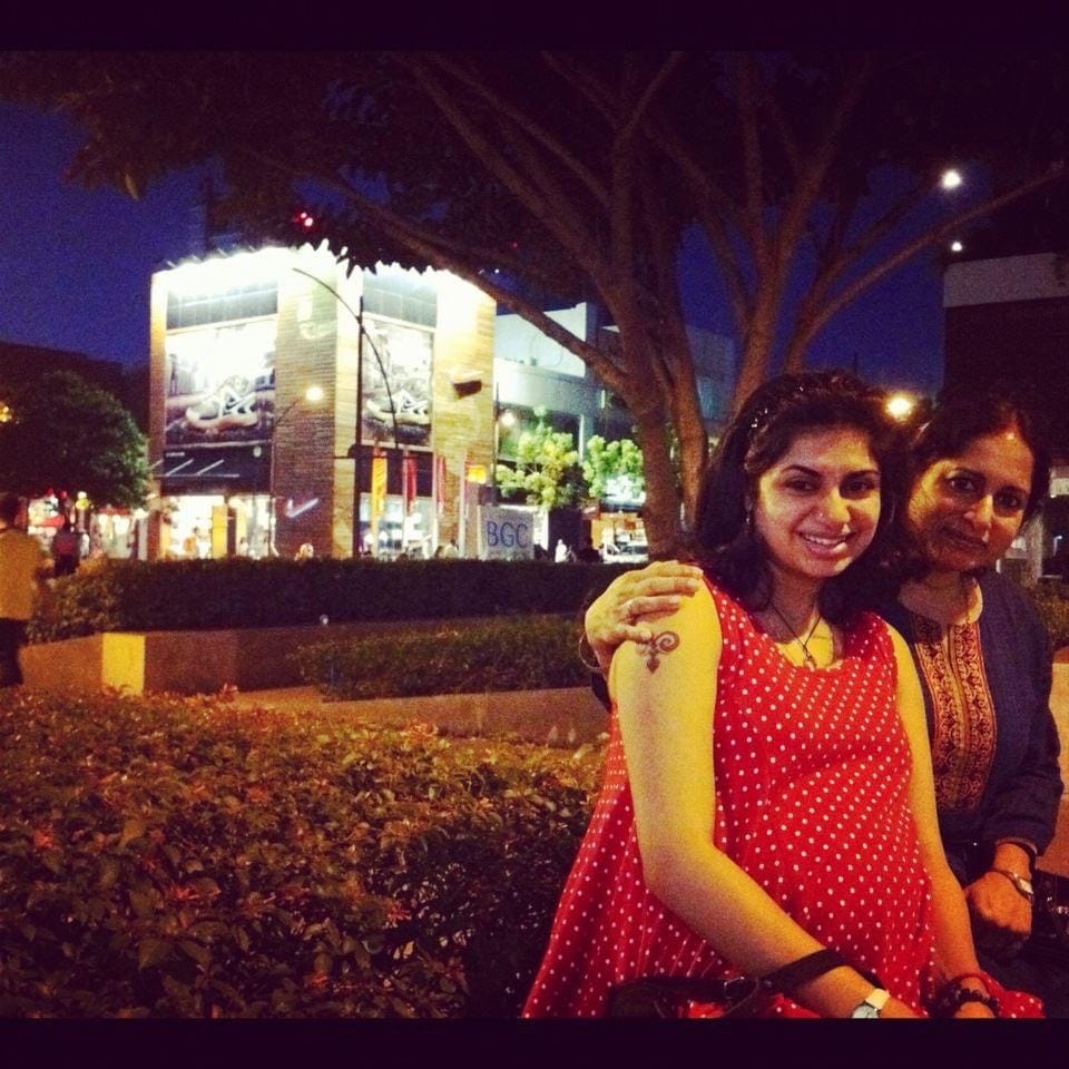 Mother and pregnant daugher, both Indian women looking at the camera.