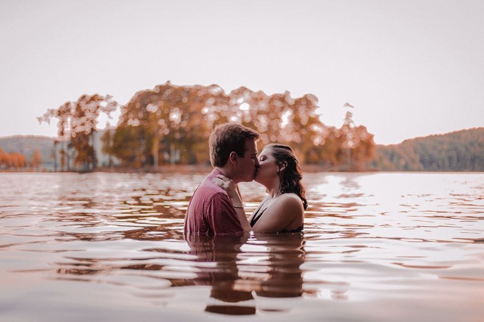 Couple kisses in a river by Wildly Wed